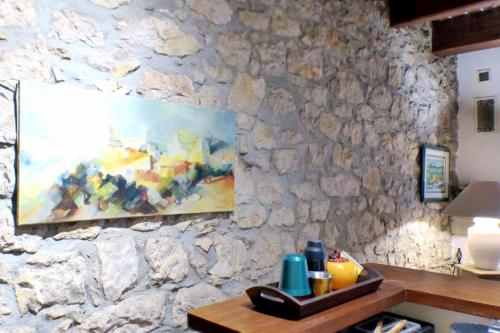 un mur en pierre avec un tableau sur une table dans l'établissement Spacious house with garden in Ollioules, à Ollioules