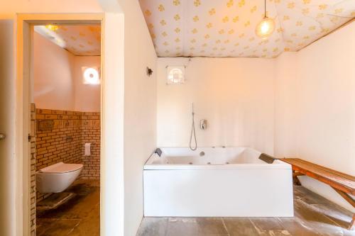 a bathroom with a tub and a toilet at Aranya by Stories in Jaipur