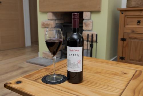 a bottle of wine and a glass on a table at Setter, Shetland Islands 