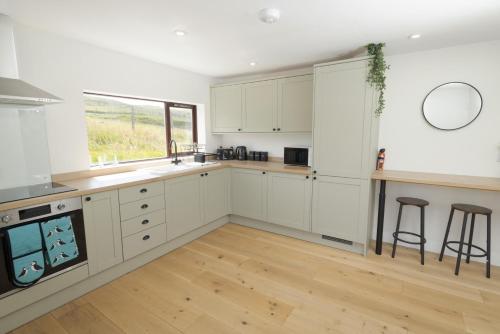 a kitchen with white cabinets and a window at Setter, Shetland Islands 