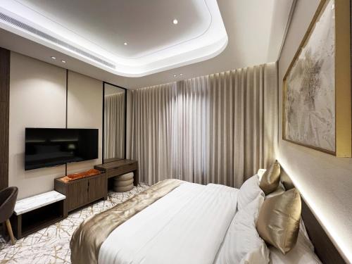 Un dormitorio con una cama y un televisor de pantalla plana. en Sadana, en Yeda