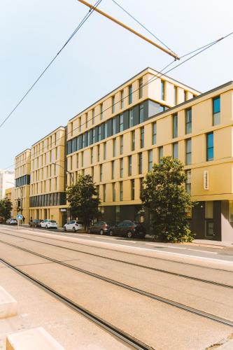 a building on a street with cars parked in front of it at Bikube Montpellier in Montpellier