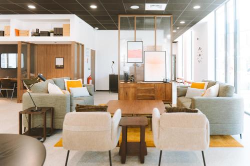 a living room with couches and a table and chairs at Bikube Montpellier in Montpellier