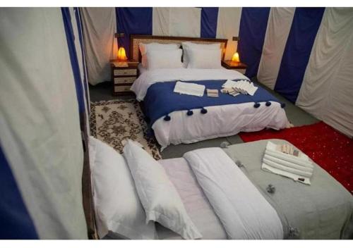 a bedroom with two beds in a tent at Sahara Luxurious Tented in Merzouga