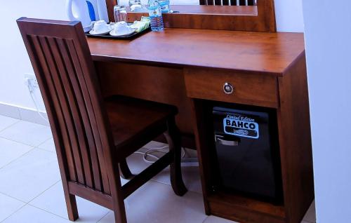 a wooden desk with a chair next to it with a sticker on it at Greenyard Beach Hotel in Entebbe