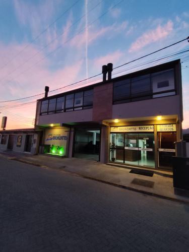 a building on a street with a store front at Pousada Bronzatto in Garopaba