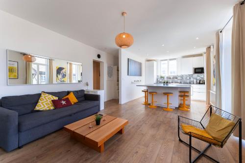 un salon avec un canapé bleu et une table dans l'établissement Colmar Terrace - BELLE ALSACE 4 - BookingAlsace, à Colmar