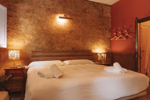 a bedroom with a large white bed with two pillows at Los Pilares de Ronda Boutique & Hotel in Ronda
