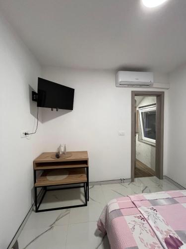 a bedroom with a bed and a tv on the wall at Apartmani Venecia in Prozor