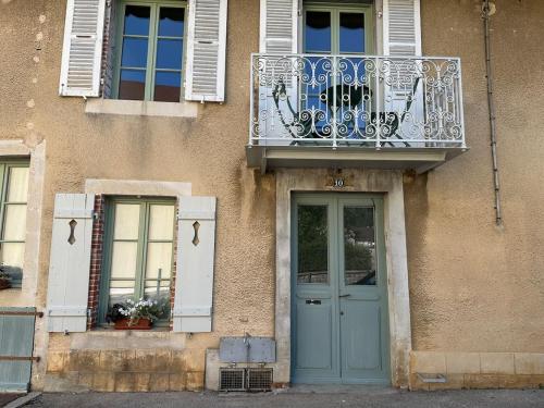 ein Gebäude mit einer blauen Tür und einem Balkon in der Unterkunft Le Relais de Paulette et Gaston in Poligny