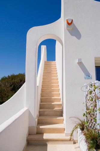 a staircase leading up to a white building with a blue sky at Fraledune in Maruggio