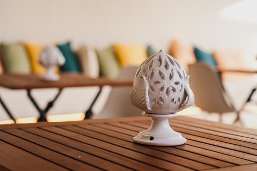 a white egg figurine on a wooden table at Fraledune in Maruggio