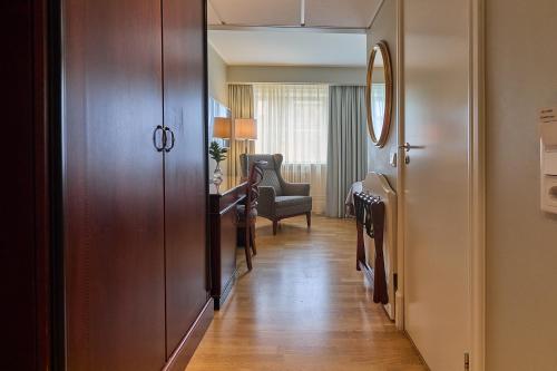 a hallway with a door and a chair in a room at Elite Hotel Mollberg in Helsingborg