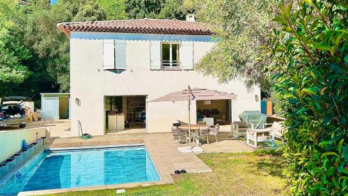 une maison avec une piscine devant une maison dans l'établissement La Villa Blanche, à Cavalaire-sur-Mer