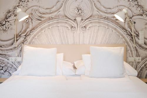 a white bed with white pillows in a bedroom at White Flat by GrazRentals with cool location & free parking in Graz