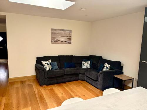 a living room with a black couch and a table at Newly renovated town house in Athlone