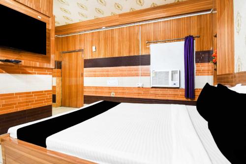 a bedroom with a bed and a flat screen tv at Hotel O Bhubaneswar City Center in Bhubaneshwar