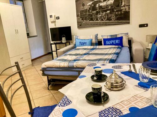 a living room with two tables and a bed at Porta 1 in Luino