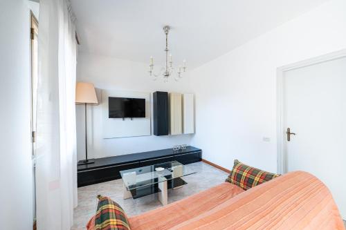 a living room with a couch and a tv at Appartamento Smeraldo Mare in Marina di Massa