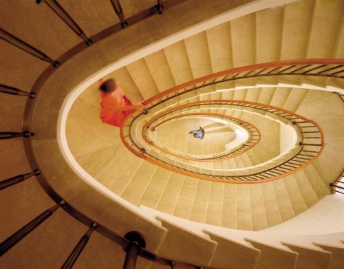 a person walking down a spiral staircase at Four Seasons Hotel Milano in Milan