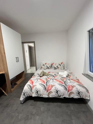 a bedroom with a large bed in a white room at Apartmani Venecia in Prozor
