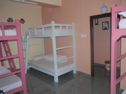 a room with two bunk beds and a clock on the wall at XTSY Travellers Hostel in Shillong