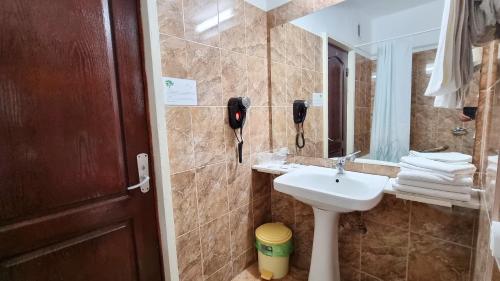 a bathroom with a sink and a phone next to a mirror at Hotel Lido in Mamaia