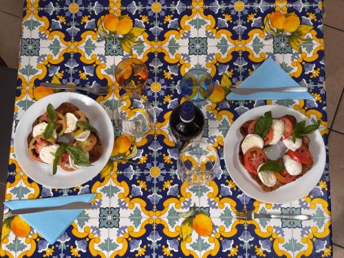 a table with two bowls of food on a blue and yellow table cloth at Rosso Napoli locazioni brevi in Naples