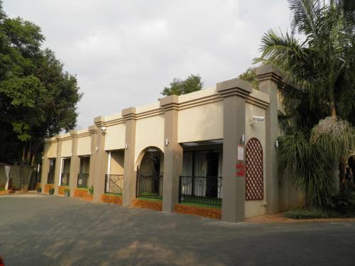 a building with a parking lot in front of it at Homestay Travel Guest House in Roodepoort