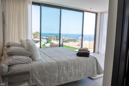 a bedroom with a bed with a view of the ocean at Villa El Padrino in Callao Salvaje
