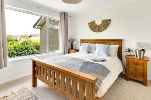 a bedroom with a bed and a large window at Cornish house 5 min drive to beach in Falmouth