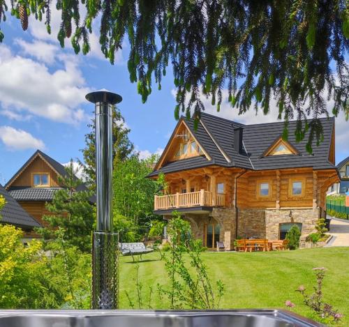 a log home with a black roof at Wood House in Nowy Targ