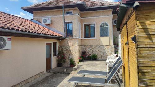 a house with a bench in front of it at Стаи за гости Роса in Rosno