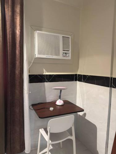 a small table and a chair in a room at سحاب الأندلس للشقق المخدومة 2 أملج Sahab Al Andalus for Served Apartments in Umm Lujj