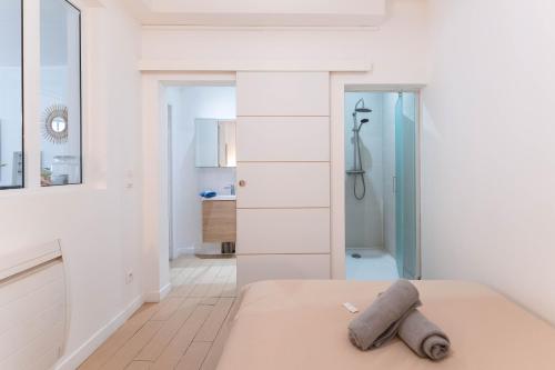 a white bedroom with a bed and a shower at Colmar City Center - Modern Studio COCOON - BookingAlsace in Colmar