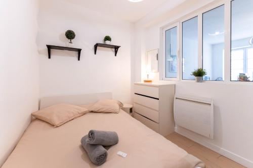 a white bedroom with a bed and a window at Colmar City Center - Modern Studio COCOON - BookingAlsace in Colmar