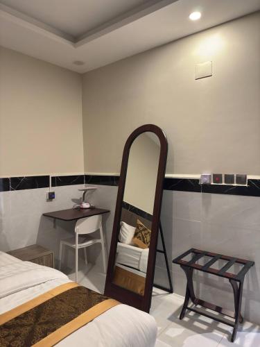 a bedroom with a bed and a mirror and a table at سحاب الأندلس للشقق المخدومة 2 أملج Sahab Al Andalus for Served Apartments in Umm Lujj