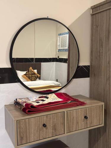 a mirror sitting on top of a dresser in a bedroom at سحاب الأندلس للشقق المخدومة 2 أملج Sahab Al Andalus for Served Apartments in Umm Lujj
