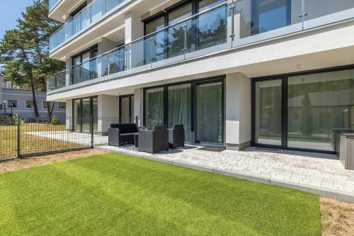 a building with a lawn in front of it at Urokliwy Apartament z Ogródkiem 150 m od Plaży Parking Międzywodzie by Noclegi Renters in Międzywodzie