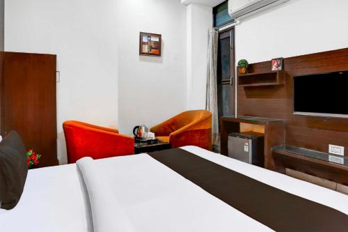 a hotel room with a bed and a flat screen tv at Hotel O Railway Station Road Near Clock Tower in Ludhiana