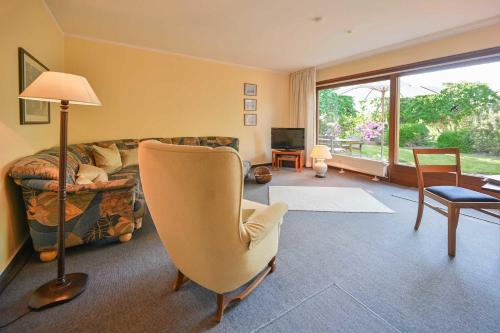 un soggiorno con un divano e una sedia di Bungalow Mumm a Dahme