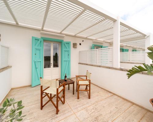 a patio with a blue door and a table and chairs at Tenuta Centoporte in Otranto