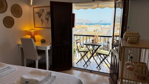 a room with a bed and a balcony with a table at Harmonia De La Mar in Altea
