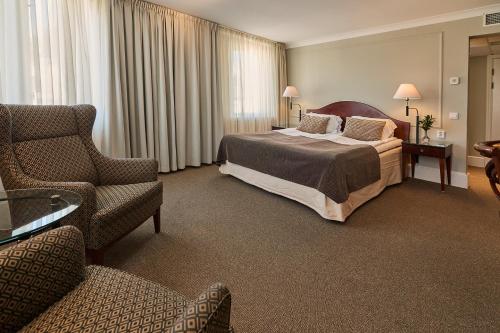 a hotel room with a bed and a chair at Elite Hotel Mollberg in Helsingborg