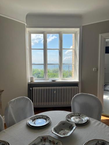 a dining room with a table and chairs and a window at Fria Bad in Helsingborg