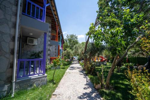 una passerella accanto a un edificio alberato di Sokakağzı Otel & Beach a Ayvacık