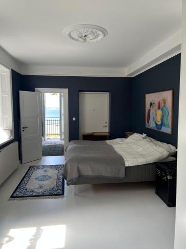 a bedroom with a bed and a blue wall at Fria Bad in Helsingborg