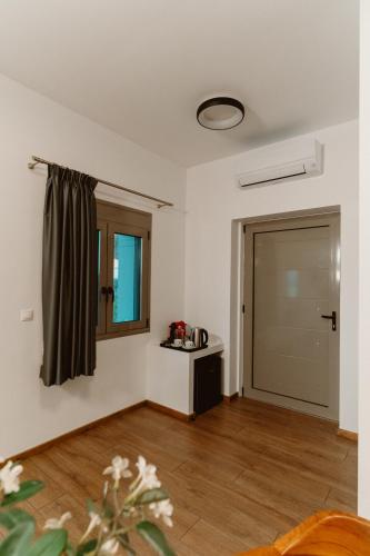 an empty room with a door and a window at Ollenia's Harmony Luxury Apartments in Derveni