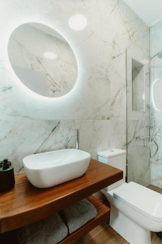 a bathroom with a sink and a toilet and a mirror at Ollenia's Harmony Luxury Apartments in Derveni