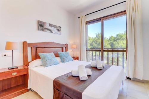 a bedroom with a bed and a large window at Villa Mar Egos by Villa Plus in Cacla D'or